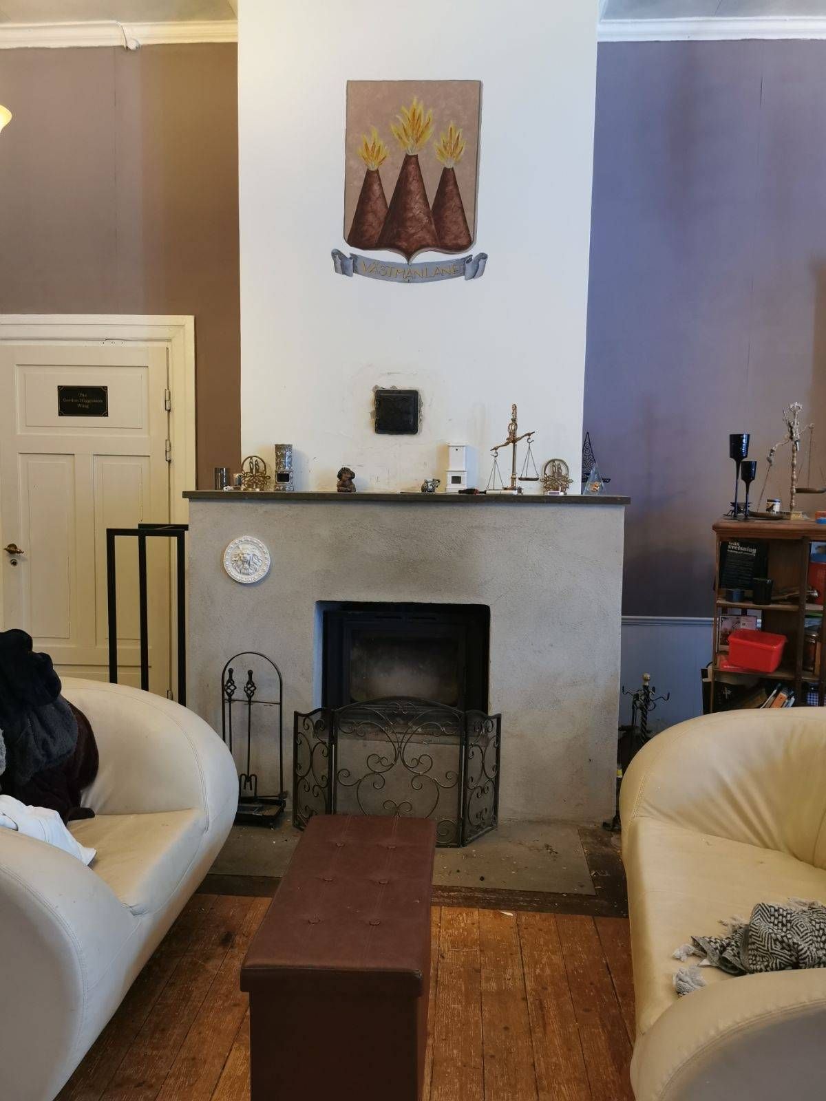 Kamin med målat landskapsvapen i allrummet