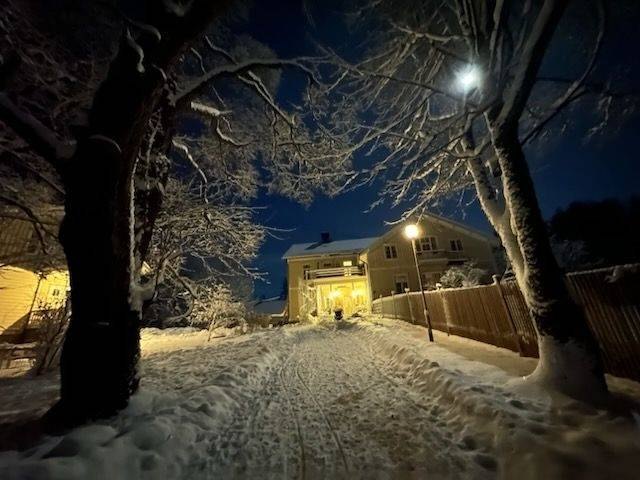 Upplyst gårdsplan med flygeln i snö