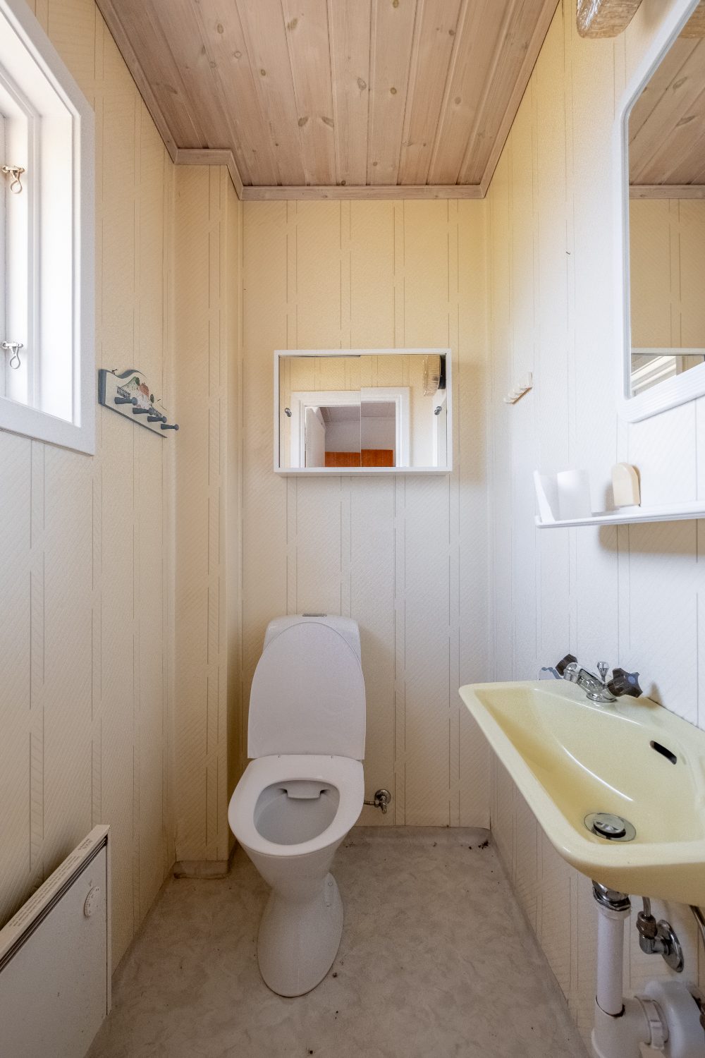 Gästtoalett med träpanel i tak
