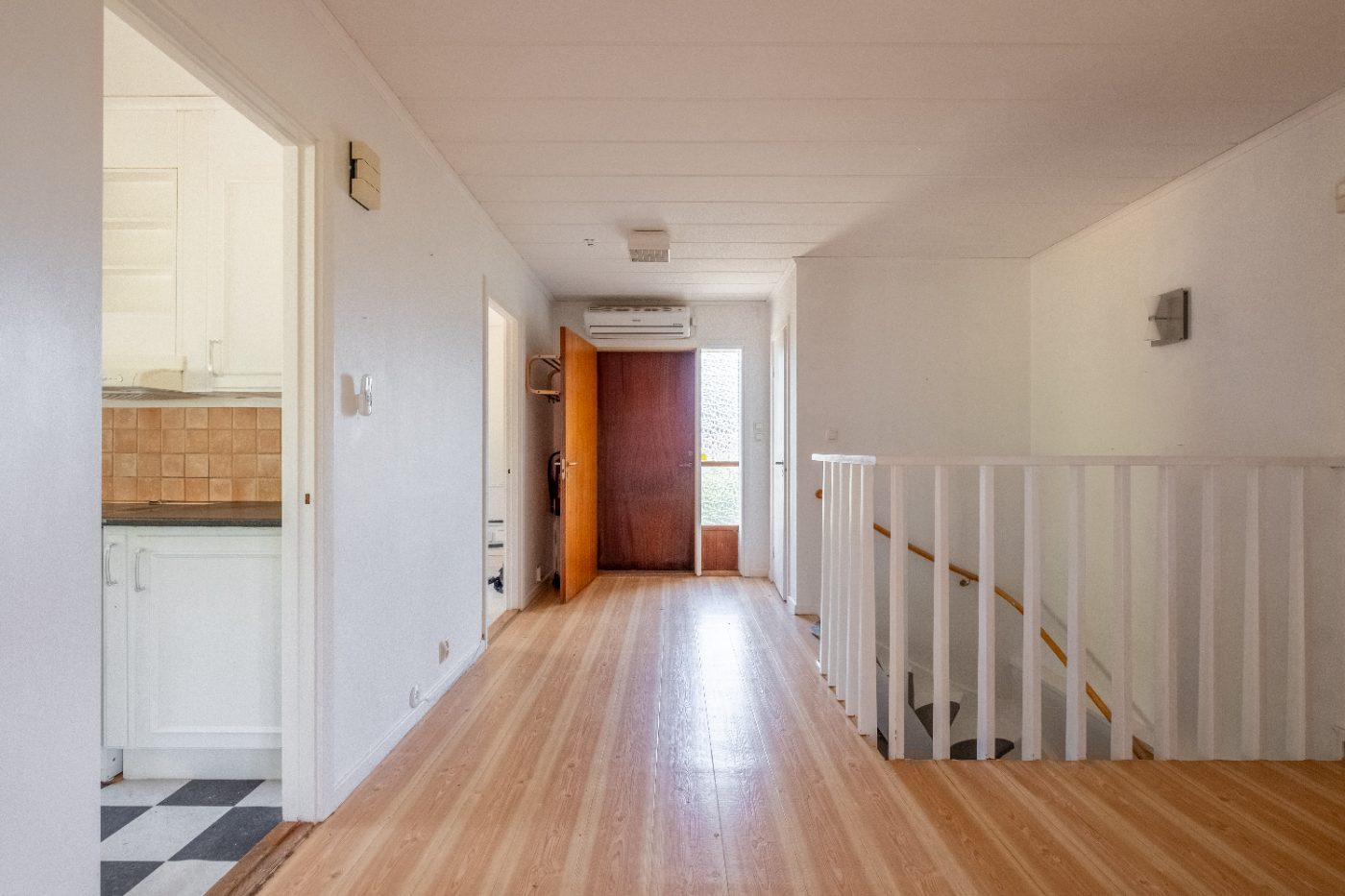 Hall med utblick mot köket med schackmönstrat golv